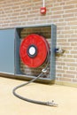 Fire hose on reel at wall Royalty Free Stock Photo