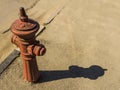 Old fire hydrant stands by the road lit by the sun Royalty Free Stock Photo