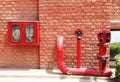 Fire hydrant,hose and pipes inserted on brick wall