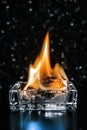 Fire inside square glass ashtray in the dark Royalty Free Stock Photo