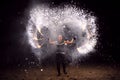 Fire juggler performing at night on the sandy beach