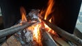 Fire on logs in fire pot with embers and burning coal and blazing flames