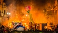 Fire men push a sculpture into the fire during Las Fallas in Valencia Spain