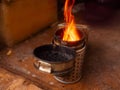 Fire in metal bee smoker standing on a wooden floor. Agriculture equipment