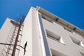 Fire metal staircase on a building tiled wall against a blue sky Royalty Free Stock Photo