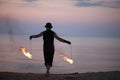 Fire performer back with burning poi on the beach Royalty Free Stock Photo