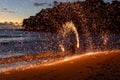 Fire performer lights up the beach, creating beautiful patterns against a sunset backdrop. Royalty Free Stock Photo