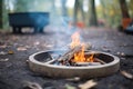 fire pit ring with burning wood in a forest campsite
