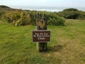 Fire pit use by reservation only sign with water in Newport, Oregon Royalty Free Stock Photo