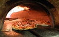 fire and pizza inside an oven in the italian pizzeria