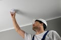 fire safety engineer installing smoke detector on house ceiling. home security and fire alarm system Royalty Free Stock Photo