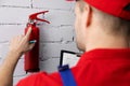 Fire safety and prevention - service worker checking extinguisher pressure Royalty Free Stock Photo