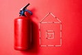 Fire safety, or security and protection concept. Fire extinguisher and the figure of the house of matches Royalty Free Stock Photo