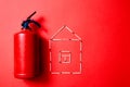 Fire safety, or security and protection concept. Fire extinguisher and the figure of the house of matches. Royalty Free Stock Photo