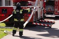 Fireman unwinds the hydrant near the fire truck