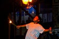 fire show artist juggles his torch breathes fire in dark air, performing amazing arts