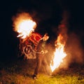 Fire Show at night. Young man stands in front of Royalty Free Stock Photo