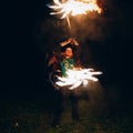 Fire Show at night. Young man stands in front of Royalty Free Stock Photo