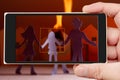 Fire on smartphone screen. Family at burning house Royalty Free Stock Photo