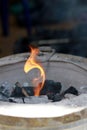 Fire starter with a flame on a charcoal stove Royalty Free Stock Photo