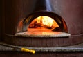 Fire stone stove oven for preparing traditional italian pizza. Fire wood burning in oven. Royalty Free Stock Photo