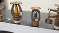 Fire sprinkler heads with fusible links and frangible bulbs