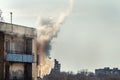 Fire on top floor of old apartment building. Clouds of smoke curling from balcony. worn electic wiring on aged house and short Royalty Free Stock Photo