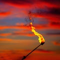 Fire torch at sunset sky with red clouds Royalty Free Stock Photo