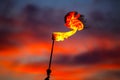 Fire torch at sunset sky with red clouds