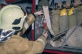 Fire truck ready to respond to emergency, firefighter checks special equipment on the fire service car before leaving Royalty Free Stock Photo