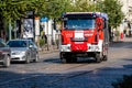 A fire truck with warning lights on goes to a call on a paved street in the city center Royalty Free Stock Photo