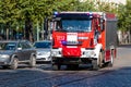 A fire truck with warning lights on goes to a call on a paved street in the city center Royalty Free Stock Photo