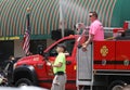 Fire trucks with firemen in a parade in small town America Royalty Free Stock Photo