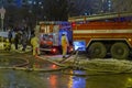 Fire trucks in work to extinguish a fire in winter at night. Text in Russian: EMERCOM of Russia Phone Fire brigade