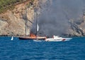 Fire on Turkish yacht in the Mediterranean Sea. A coast guard boat and two small boats came to the rescue. The yacht is all on fir