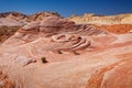 Fire wave with swirly layers of deposited sandstone during wonderful sunny day with blue sky, in Valley of Fire State Park Royalty Free Stock Photo