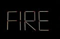 Fire writing made by matches on black backgroung Royalty Free Stock Photo