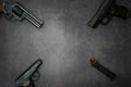 Firearms laid out along the line. Three guns pistols, cartridges close-up on a gray concrete background. copy space