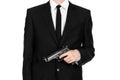 Firearms and security topic: a man in a black suit holding a gun on an isolated white background in studio Royalty Free Stock Photo