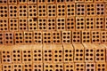 Rows of fired clay bricks with many holes abstract horizontal background
