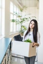 Fired female employee holding box of belongings in an office Royalty Free Stock Photo