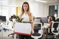 Fired female employee holding box of belongings in an office Royalty Free Stock Photo