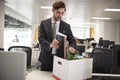 Fired male employee packing box of belongings in an office