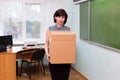 Fired sad teacher leaves the school office with a box of things