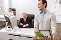 Fired smiling employee carrying the box and quitting the job Royalty Free Stock Photo