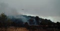 Wildfire in mountain forest, the firefight helicopter fly and dropping water