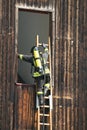 Firefighter in action enters through a window to rescue people Royalty Free Stock Photo