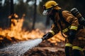 Firefighter in action extinguishing house fire from behind with powerful gushing water from the hose