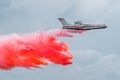 Firefighter airplane drops red water on a fire in the forest. Royalty Free Stock Photo