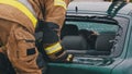 Firefighter beraking glass on car window extricate trapped victim from the car Royalty Free Stock Photo